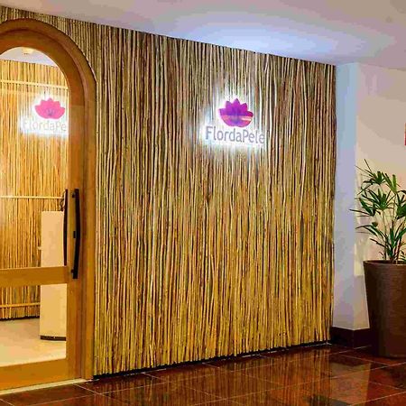 Hotel Luzeiros Sao Luis Экстерьер фото The photo shows the entrance to a spa or wellness center named "FlordaPel." The wall is decorated with natural-looking materials, resembling bamboo or reeds, giving it an organic feel. A soft-lit sign with the logo is placed above the entrance, and t