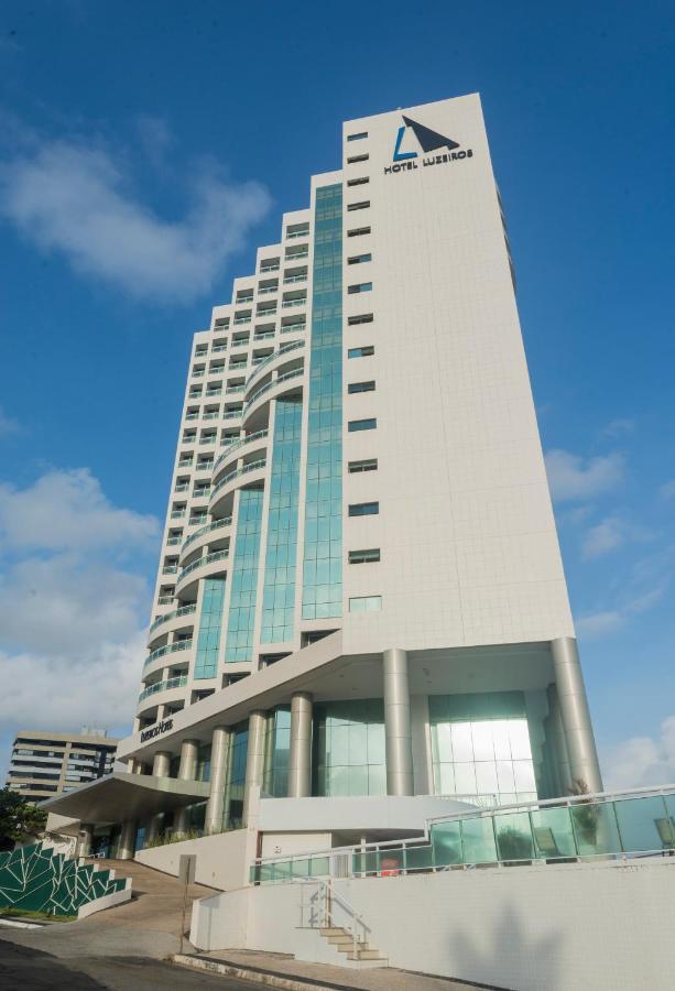 Hotel Luzeiros Sao Luis Экстерьер фото The photo shows a modern, multi-story building with a sleek design. The exterior features a combination of white panels and large glass windows, creating a clean and contemporary appearance. The building has a unique architectural shape, with curved 