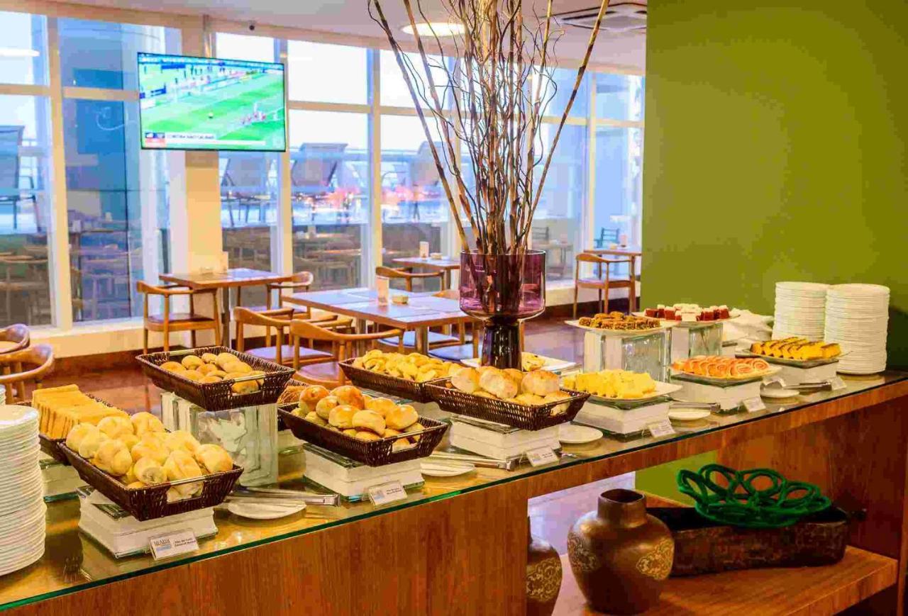 Hotel Luzeiros Sao Luis Экстерьер фото The photo shows a buffet setup in a dining area. There are several baskets displaying a variety of baked goods, including different types of bread and pastries. The table is arranged neatly with plates and utensils, and there is a decorative element 