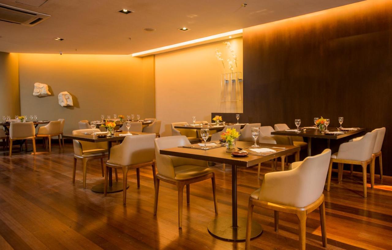 Hotel Luzeiros Sao Luis Экстерьер фото The photo depicts a modern restaurant interior. It features wooden flooring and tables set with elegant tableware, including glasses and flowers. The seating consists of upholstered chairs, adding a touch of comfort. The lighting is soft and ambient,