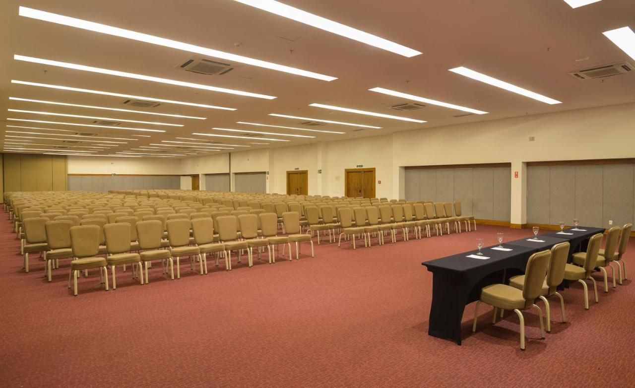Hotel Luzeiros Sao Luis Экстерьер фото The photo shows a large, empty conference room. There are rows of beige chairs arranged neatly facing forward, indicating that the space is set up for an event or presentation. At the front of the room, there is a long black table with a few chairs a