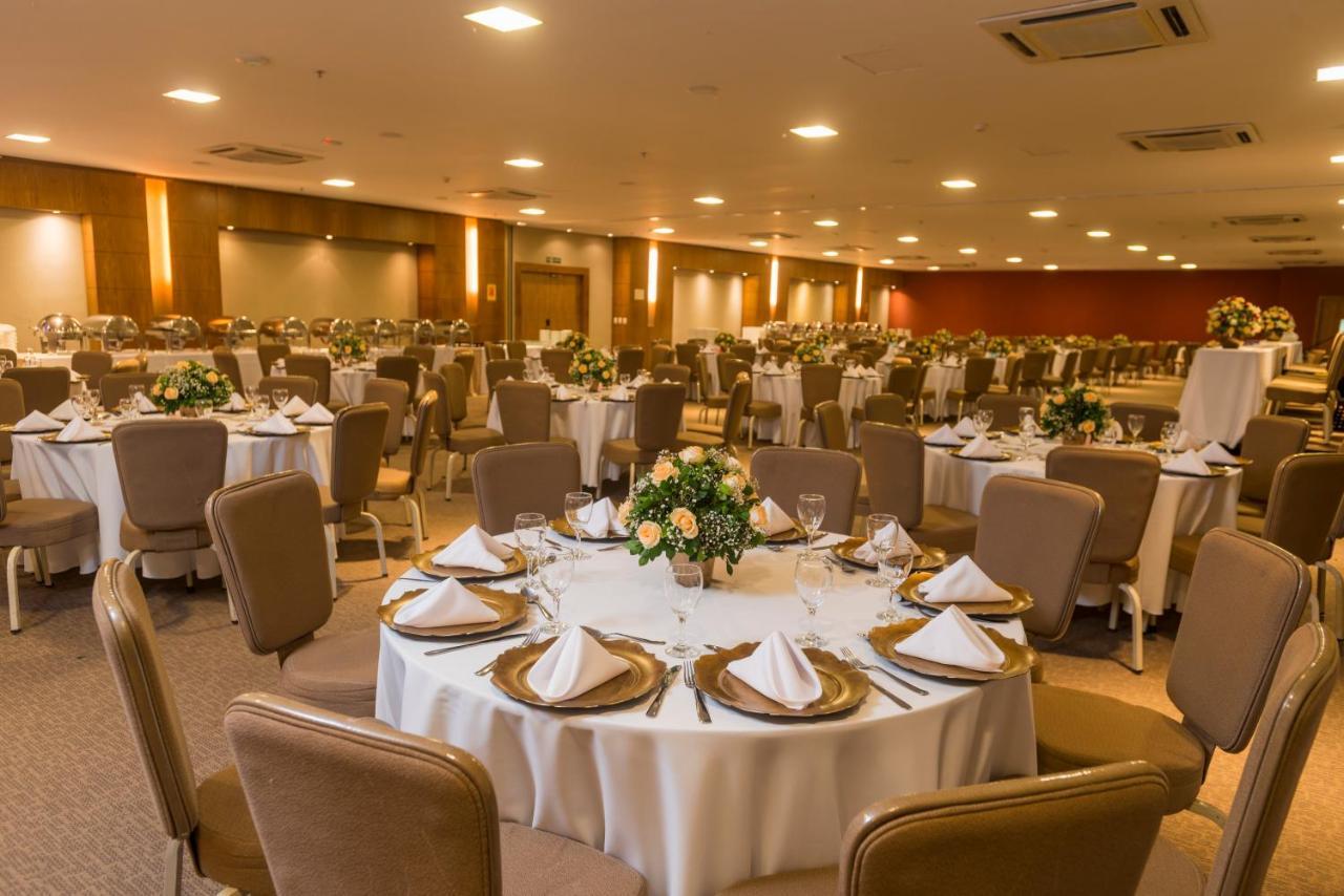 Hotel Luzeiros Sao Luis Экстерьер фото The photo depicts a spacious banquet hall set up for an event. Numerous round tables are elegantly arranged with white tablecloths and neatly folded napkins. Each table features a small floral centerpiece. The room is well-lit, with warm lighting hig