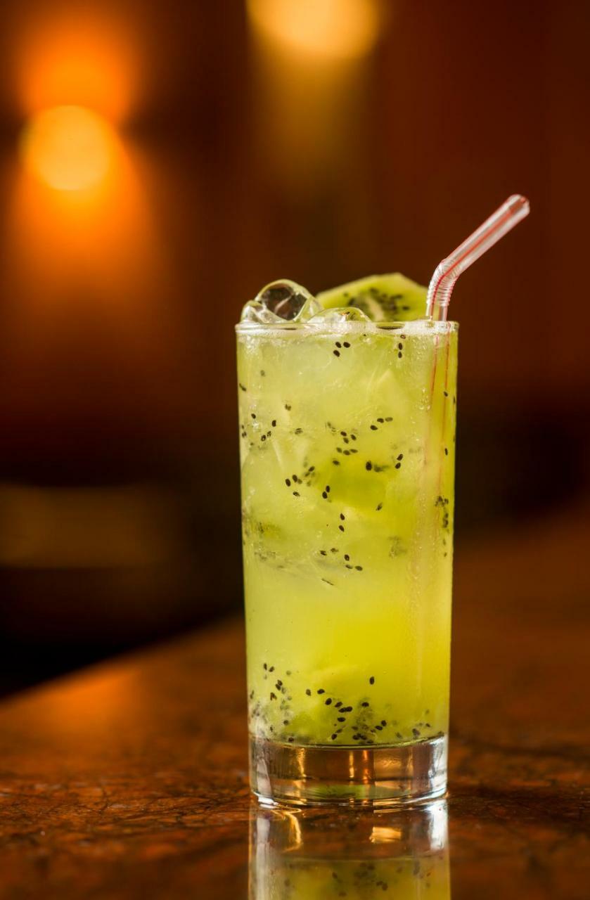 Hotel Luzeiros Sao Luis Экстерьер фото The image features a tall glass filled with a refreshing, green beverage. The drink is a light, vibrant green color and contains ice cubes, adding to its chill appeal. Floating within the drink are small black seeds, likely from a fruit ingredient. A